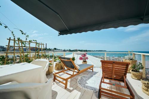een balkon met een tafel en stoelen en de oceaan bij San Marco Luxury Rooms Umag in Umag