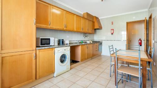 a kitchen with wooden cabinets and a washer and dryer at Villas Boas House Silves in Silves