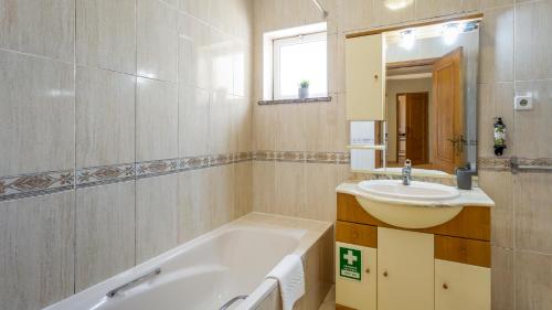 W łazience znajduje się wanna, umywalka i lustro. w obiekcie Villas Boas House Silves w mieście Silves