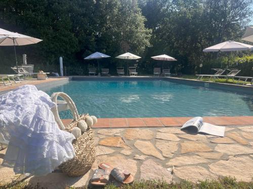a swimming pool with a picnic basket next to it at Antico Casale Rodilosso in Montaione