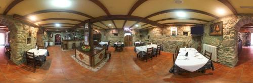 um restaurante com mesas e cadeiras num edifício de pedra em Casa Rural Outeiro em Outeiro