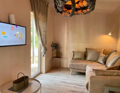 a living room with a couch and a flat screen tv at MOSS and pines by the sea with private parking in Ventspils