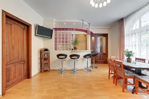 a living room with a kitchen and a table with stools at Dom Artysty in Sopot