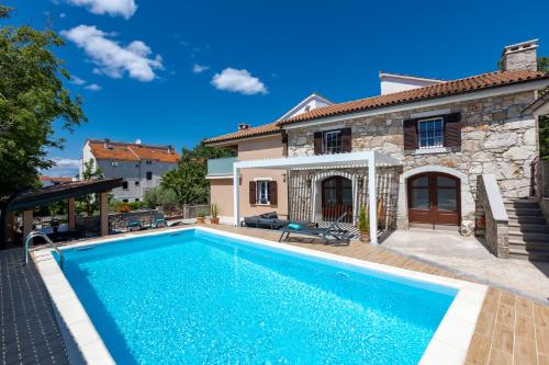 Villa con piscina frente a una casa en Mary's Villa with heated pool & game room, en Malinska