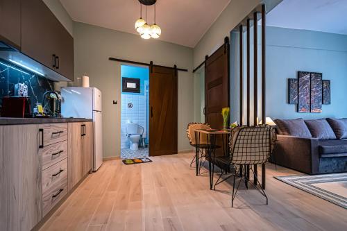 塞薩羅尼基的住宿－One Salonica Deluxe Apartment 2，厨房以及带桌椅的起居室。