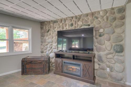a living room with a stone wall with a fireplace at Beautiful Bellaire Home with Amenities, 4 Mi to Lake in Bellaire