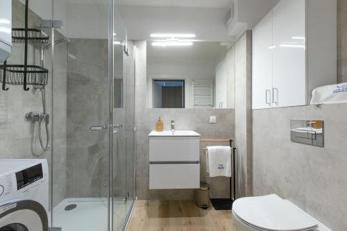 ein Badezimmer mit Dusche, Toilette und Waschbecken in der Unterkunft Apartament Szafirowy by Major Domus Club in Dziwnów