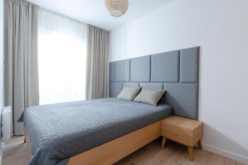 Schlafzimmer mit einem Bett mit einem großen Kopfteil in der Unterkunft Apartament Szafirowy by Major Domus Club in Dziwnów
