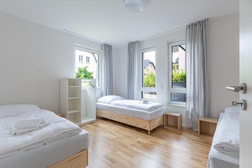 a white room with two beds and two windows at T&K Apartments - Bergisch Gladbach - 3 Comfortable Apartments - 18 min to Fair Messe Cologne in Bergisch Gladbach