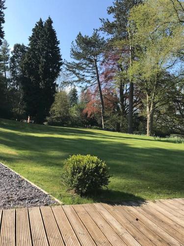 a park with a field of grass and a wooden bench at Log cabin rural retreat in beautiful countryside in Lapworth