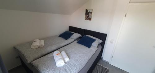 a bed with blue and white pillows on it at Ferienwohnung - Nachtigall in Bad Hersfeld