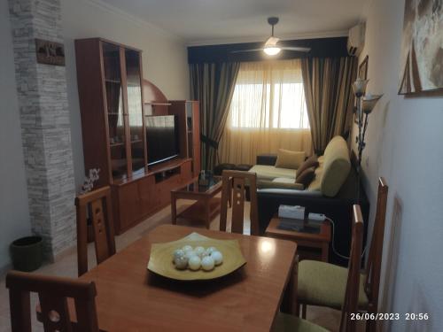 una sala de estar con una mesa y un sofá en Apartamento VILLA INÉS parking y wifi gratis, en Huércal de Almería