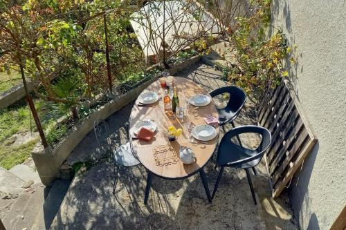 una mesa de madera y 2 sillas en el balcón en Loft rural - terrasse parking et vue en Ferrières-sur-Ariège