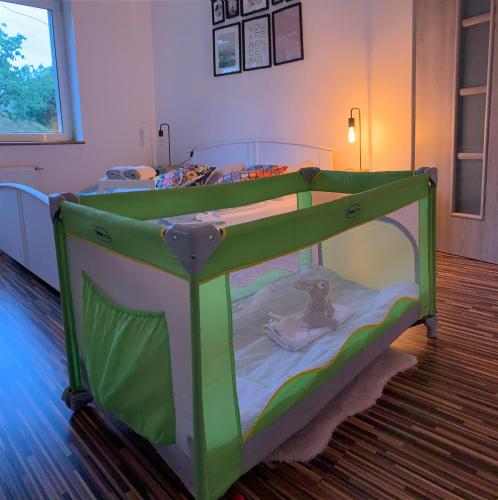 a green crib in a room with a bedroom at Noclegi Little Sheep in Chojna