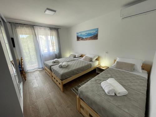 a bedroom with two beds and a window at PLOMIN SKY&BAY in Plomin