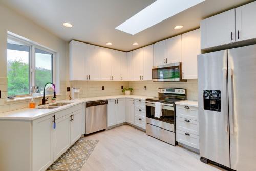 uma grande cozinha com armários brancos e uma clarabóia em Lakefront Bremerton Vacation Rental with Hot Tub! em Brinnon