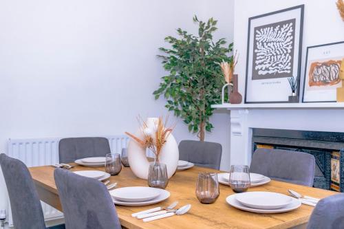 a dining room table with chairs and a fireplace at Templar House - Sleeps 6, Special Weekly Monthly Stay Rates, Central Location with FREE Parking, FREE WiFi, Perfect for ALTON TOWERS & M6 in Stoke on Trent