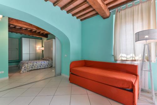 a living room with a red couch and a bedroom at Appartamento sul Mare a Rio Marina, Isola d'Elba in Rio Marina