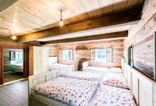 a bedroom with two beds and a wooden ceiling at Soví Újezd in Jestřebí