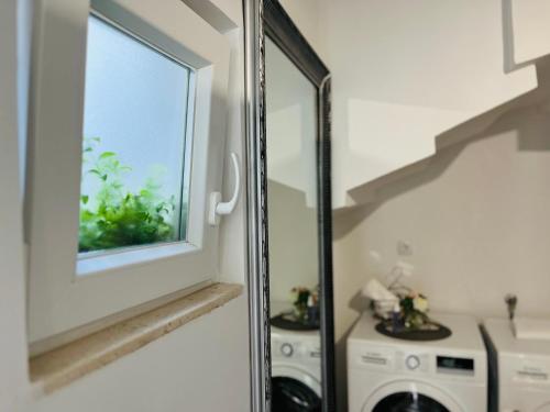a laundry room with a window and a washing machine at Apartment Stari Dvor in Kaštela