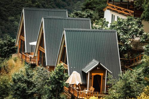 een huis met een groen dak en een veranda bij Ayliya bungalow in Trabzon