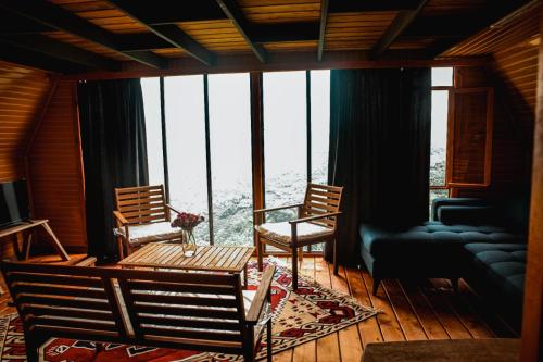 ein Wohnzimmer mit 2 Stühlen und einem Tisch vor einem Fenster in der Unterkunft Ayliya bungalow in Trabzon