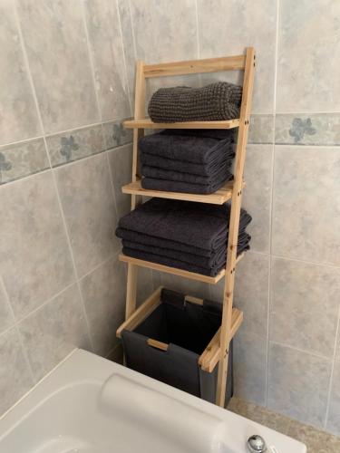 a bathroom with a wooden towel rack next to a sink at Casa Anhelando Andalucia - Een villa prachtig op een heuveltop met magnifiek uitzicht nabij dorp en strand in Iznate