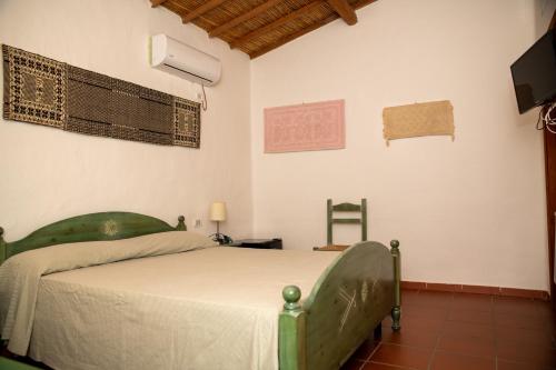 a bedroom with a green bed in a room at Agriturismo Santa Lucia in Tratalias