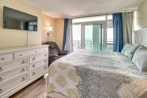 a bedroom with a bed and a dresser with a television at Oceanfront Myrtle Beach Condo with Pools and Hot Tubs in Myrtle Beach