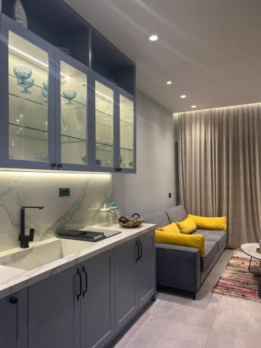 a kitchen with a sink and a couch in a room at D'azur Home in Vlorë