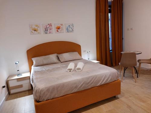 a bedroom with a bed with two white shoes on it at B&B Terrazza In Centro in Castellammare di Stabia