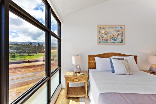 a bedroom with a bed and a large window at Kahana Villa E701 in Kahana