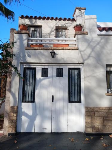 Casa blanca con puerta y ventanas blancas en Quinta sección Depto. Equipado en Mendoza