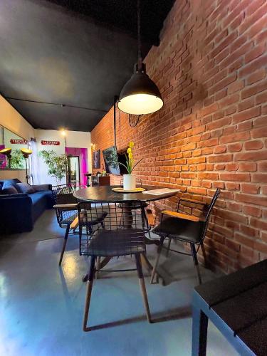 a dining room with a brick wall and a table and chairs at Industrial Cozy Gzira Apt, Prime Spot, Sep Deal in Il-Gżira