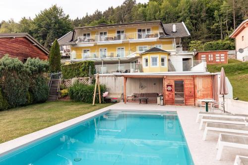 a large swimming pool in front of a house at Sun & See in Velden am Wörthersee