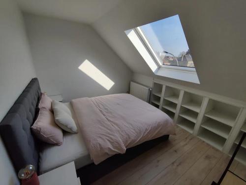 a small bedroom with a bed and a window at Bel-etage Bruges Homestay - Free parking - Entire floor in Bruges