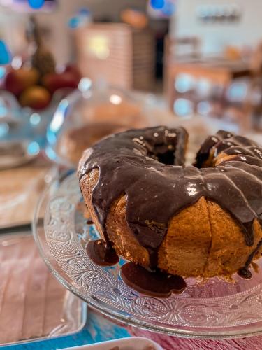 a chocolate covered bundt cake on a glass plate at Pousada Porto Girassol in Abraão
