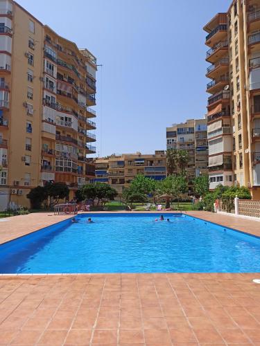 a large swimming pool in a city with buildings at Estudio Copenhague in Torremolinos