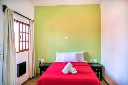a bedroom with a red bed with two towels on it at Hotel Colonial Playa del Carmen in Playa del Carmen