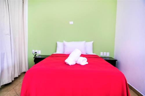 a red bed with two white towels sitting on it at Hotel Colonial Playa del Carmen in Playa del Carmen