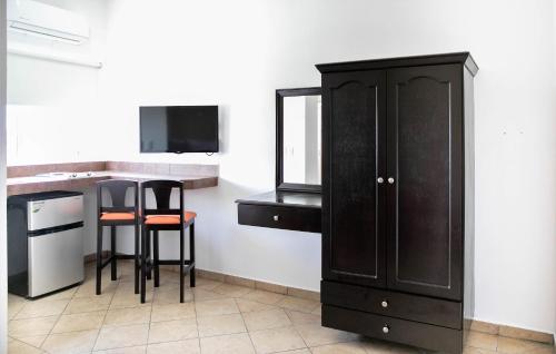 a kitchen with a cabinet and a table and stool at Hotel Colonial Playa del Carmen in Playa del Carmen