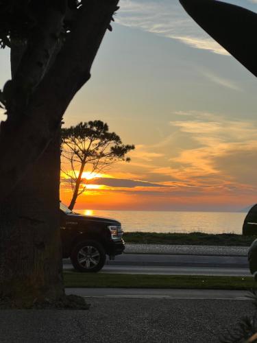 a truck driving down a road with the sunset in the background at D'azur Home in Vlorë