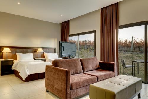 a hotel room with a bed and a couch at Auberge Du Vin, a Tribute Portfolio Hotel in Tupungato