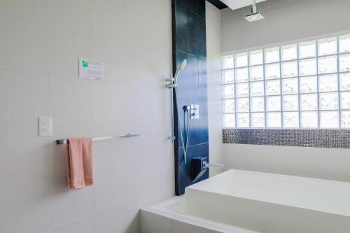 a white bathroom with a shower and a sink at Hotel Colonial Playa del Carmen in Playa del Carmen
