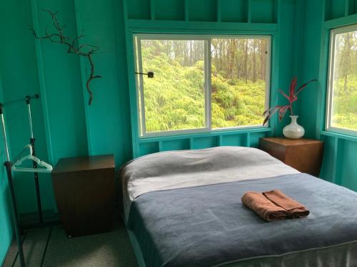 ein blaues Schlafzimmer mit einem Bett und einem Fenster in der Unterkunft Simple Rustic studio deluxe bed in tropical fruits garden in Mountain View