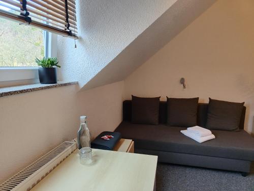 een woonkamer met een bank en een fles op een tafel bij Haus des Sports in Bad Kreuznach