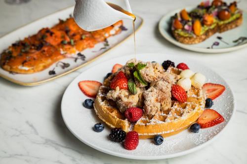 a plate of food with fruit on a table at Le Meridien Pasadena Arcadia in Arcadia