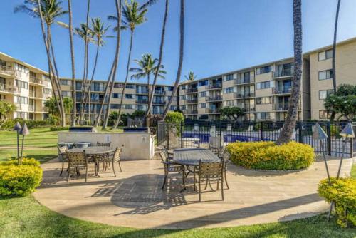 a patio with tables and chairs in front of a building at Kanai A Nalu 210 in Wailuku