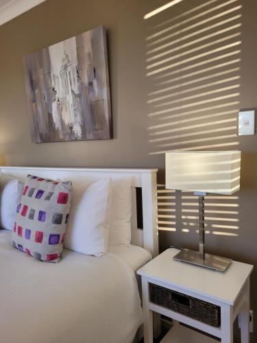 a bedroom with a bed and a table with a lamp at Hazelwood Mapua in Mapua