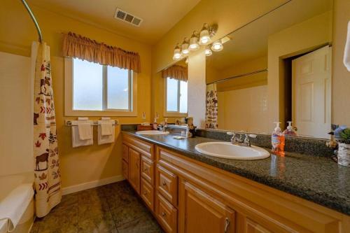 ein Badezimmer mit zwei Waschbecken und einem großen Spiegel in der Unterkunft Elk Meadow Cabins 13A Bears Den Suite in Orick